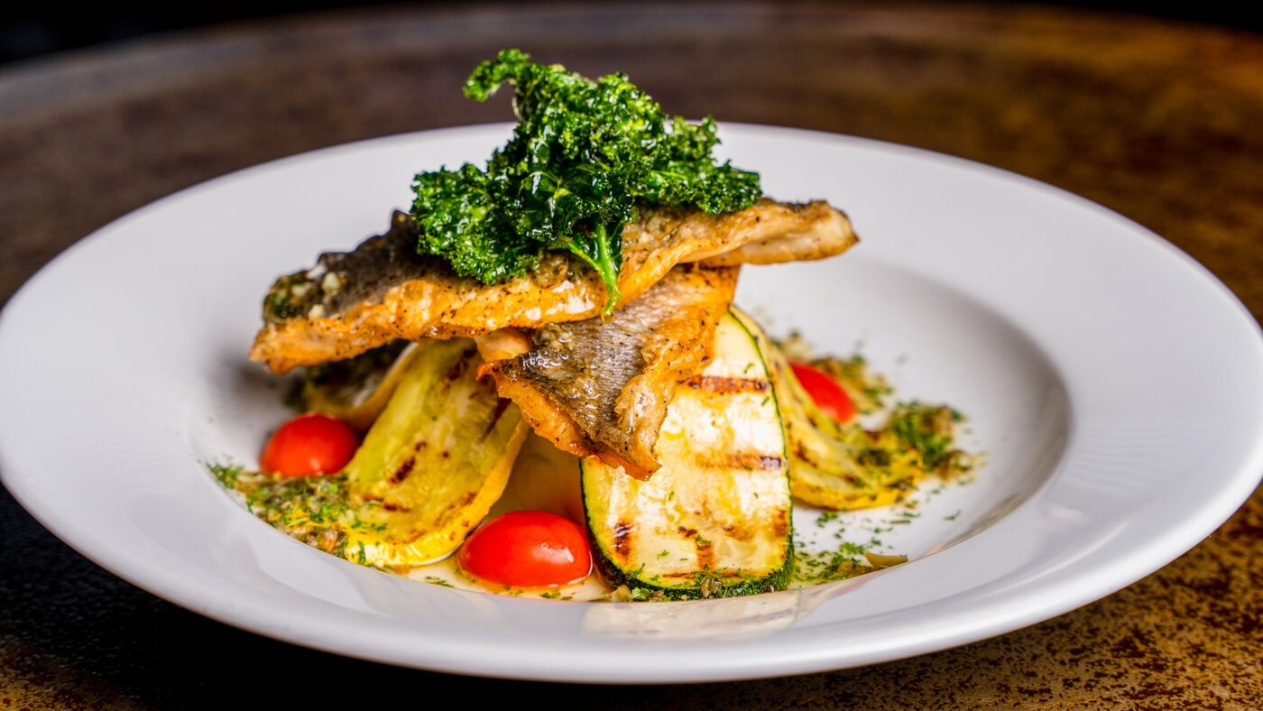 Seared branzino over grilled zucchini and squash with crispy kale