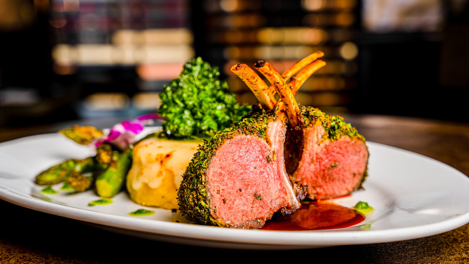 Herb-crusted rack of lamb over mashed potato with roasted vegetables